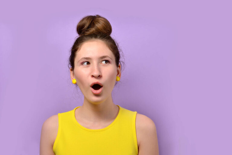 Junge Frau im gelben Shirt beim Singen Üben vor violettem Hintergrund